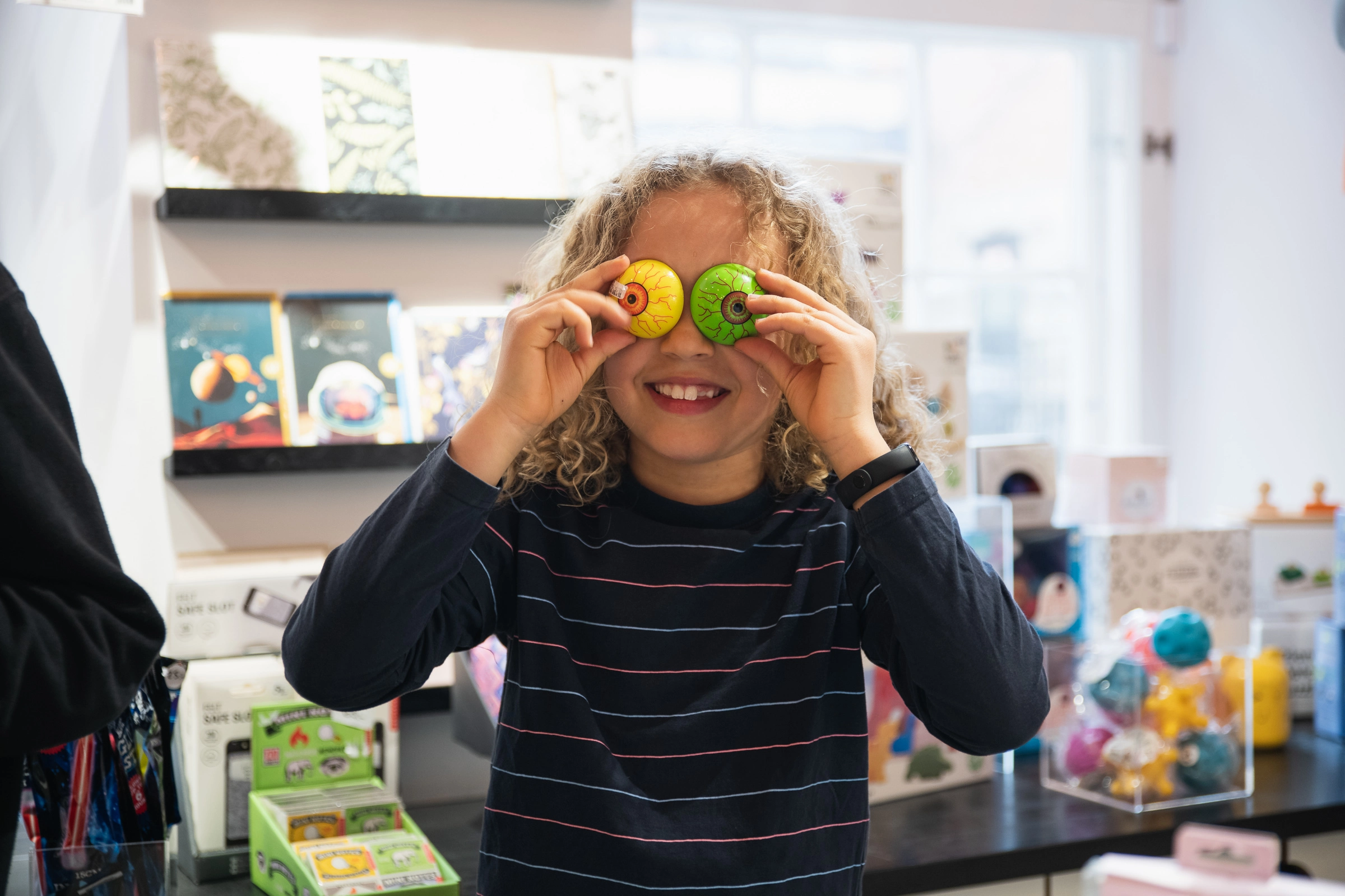 Ett barn leker med två leksaksögon i butiken